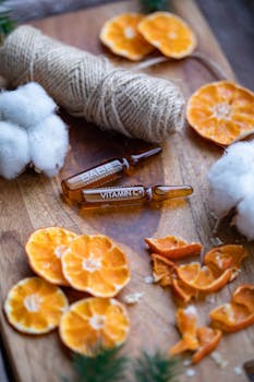 Natural skincare setup featuring vitamin C serums, dried orange slices, cotton, and twine.